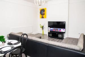 uma sala de estar com um sofá e uma televisão em A luxury 2 bedroom flat in NN1 em Northampton