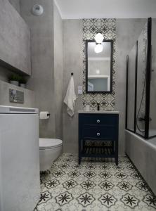 y baño con lavabo, aseo y espejo. en Blue Rooster Apartment. Cozy and quiet place to stay en Varsovia