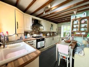 cocina con bañera grande y lavamanos en Wisteria Cottage an authentic and enchanting cottage experience, en Aberdare