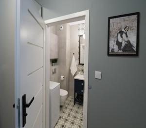 Łazienka z białą toaletą i umywalką w obiekcie Blue Rooster Apartment. Cozy and quiet place to stay w Warszawie