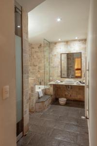 y baño con bañera, lavamanos y ducha. en Tambo del Arriero Hotel Boutique, en Cusco