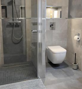 een badkamer met een douche, een toilet en een wastafel bij Apartment K21 - Győr in Győr