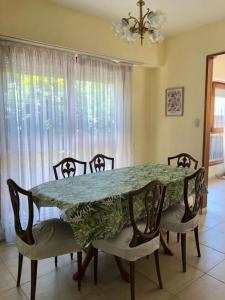 馬德普拉塔的住宿－Alma de playa，一间带桌椅、桌子和窗户的用餐室
