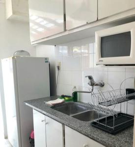 a kitchen with a sink and a microwave at Alma de playa in Mar del Plata