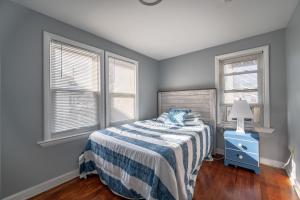 ein Schlafzimmer mit einem Bett und zwei Fenstern in der Unterkunft 208 Cottage 5 Yellow 1st unit in Ocean City