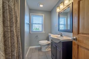 ein Badezimmer mit Waschbecken, Toilette und Spiegel in der Unterkunft 208 Cottage 5 Yellow 1st unit in Ocean City