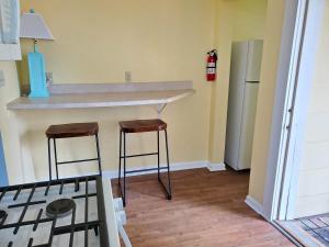 eine Küche mit Theke und zwei Barhockern in der Unterkunft 208 Cottage 5 Yellow 1st unit in Ocean City