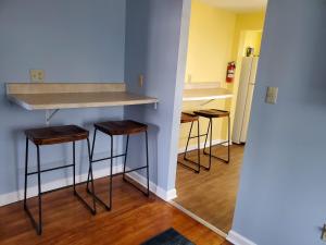eine Küche mit einer Theke und Hockern in einem Zimmer in der Unterkunft 208 Cottage 5 Yellow 1st unit in Ocean City + 4 Fotos