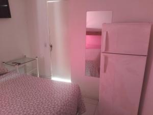 a bedroom with a bed and a refrigerator at Flat Beach Itamaracá - pousada FBI in Itamaracá