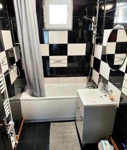 a bathroom with a black and white checkered wall at CID APARTMENT CAVNIC in Cavnic