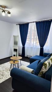 a living room with a blue couch and a mirror at CID APARTMENT CAVNIC in Cavnic