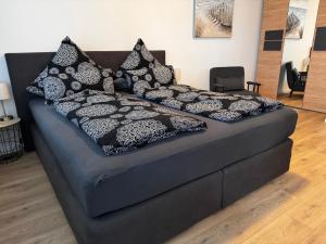 een zwart bed met zwart-witte kussens erop bij Ferienwohnung Havenwelten in Bremerhaven