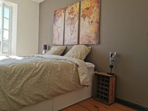 1 dormitorio con 1 cama con 2 mapas en la pared en Gîte Le Bonheur en Hiersac