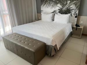 1 cama grande con banco en un dormitorio en Flat Boulevard Side 2104 Altissimo Padrão com Lazer en Salvador