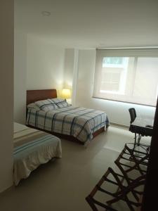 um quarto com uma cama, uma secretária e uma janela em Cartagena Beach Condo - 1400 sq. Ft. (130 m2) em Cartagena de Indias