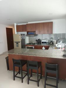 a kitchen with a counter with four stools at Cartagena Beach Condo - 1400 sq. Ft. (130 m2) in Cartagena de Indias