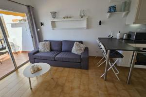 een woonkamer met een blauwe bank en een tafel bij Canarios III SeaView in Patalavaca