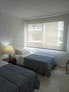 - 2 lits dans une chambre avec fenêtre dans l'établissement Cartagena Beach Condo - 1400 sq. Ft. (130 m2), à Carthagène des Indes