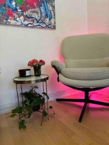 a living room with a chair and a table with flowers at Studioleilighet in Oslo