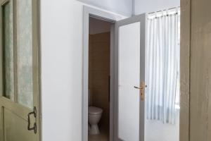 a bathroom with a door open to a toilet at Himara Hostel in Himare