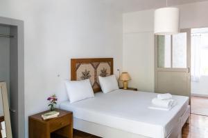 a bedroom with a white bed with white pillows at Himara Hostel in Himare