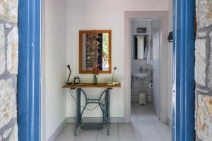 a bathroom with a table and a mirror and a sink at Himara Hostel in Himare
