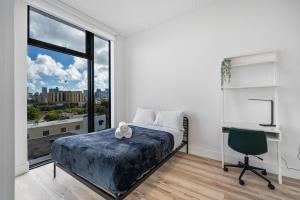 マイアミにあるPastel Apartmentsのベッドと机と窓のある寝室