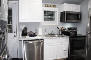eine Küche mit weißen Schränken und einer Spüle aus Edelstahl in der Unterkunft Great Outdoors in Lagrange in LaGrange