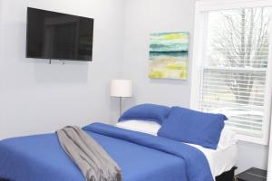 a bedroom with a blue bed and a flat screen tv at Great Outdoors in Lagrange in LaGrange