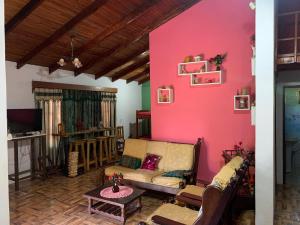 a living room with a pink wall and a couch at Terra bela in Puerto Iguazú