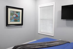 ein Schlafzimmer mit einem Fenster und ein Bett mit einer Decke in der Unterkunft Great Outdoors in Lagrange in LaGrange