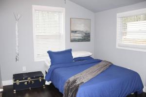 ein Schlafzimmer mit einem blauen Bett und einem Koffer in der Unterkunft Great Outdoors in Lagrange in LaGrange