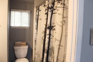 a bathroom with a toilet and a shower curtain with trees at Great Outdoors in Lagrange in LaGrange +24 photos