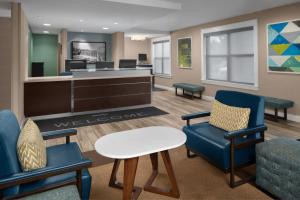 a waiting room with chairs and a table and a desk at Residence Inn Boston Dedham in Dedham