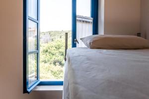 a bedroom with a bed next to a window at Himara Hostel in Himare