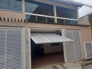 ein Gebäude mit einer offenen Garagentür mit Markise in der Unterkunft Casa de praia em Mar Grande-Ilha Itaparica in Vera Cruz de Itaparica
