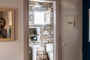 a bathroom with a stone wall and a sink at Himara Hostel in Himare
