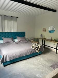 a bedroom with a blue bed and a table at Blue River in Minca