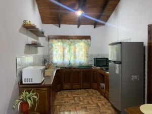 a kitchen with wooden cabinets and a refrigerator at Hospedaje Terra Bela in Puerto Iguazú