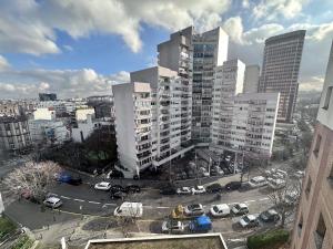 une ville avec de grands bâtiments et des voitures dans un parking dans l'établissement Accès direct à Paris - Studio confort, à Pantin