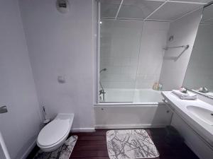 La salle de bains blanche est pourvue de toilettes et d'un lavabo. dans l'établissement Accès direct à Paris - Studio confort, à Pantin
