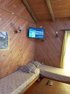 Habitación con 2 camas y TV en una cabaña en Cabañas Colliguay, Quilpué., en Quilpué