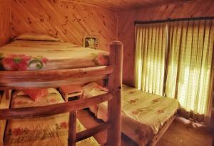 1 dormitorio con 2 literas en una cabaña de madera en Cabañas Colliguay, Quilpué., en Quilpué