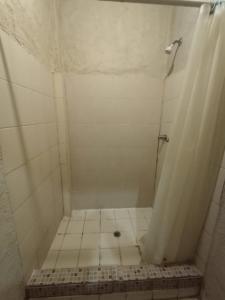 a bathroom with a shower with a tiled floor at Hotel Chinesca in Mexicali