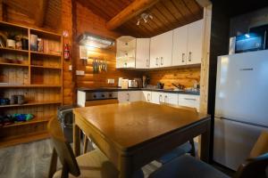 eine Küche mit einem Tisch und einem Kühlschrank in der Unterkunft Luxury Log Cabin Hideaway in Rural Snowdonia by Seren Short Stays in Trawsfynydd