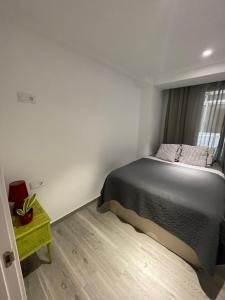 a bedroom with a bed and a table and a window at Igidelux 2 in Villajoyosa