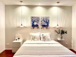 una camera da letto con un letto e due dipinti alle pareti di Le cocon des 3 frères - Paris CDG/Stade de France a Goussainville