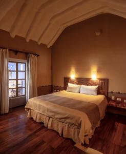 Un dormitorio con una cama grande y una ventana en Tambo del Arriero Hotel Boutique, en Cusco
