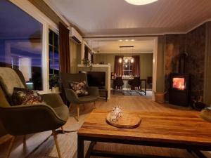 sala de estar con sofá, mesa y TV en Solhaug en Torpo