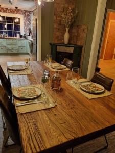 una mesa de madera con platos y copas de vino. en Solhaug en Torpo